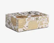 Rektangulær æske med blank hvid overflade, dekoreret med indviklede guldfarvede blomstermønstre på alle synlige sider. Blomsterne er præget, hvilket giver et tekstureret og luksuriøst udseende. Æsken har et hængslet låg og skarpe, rene kanter, hvilket gør den velegnet til dekoration eller opbevaring.