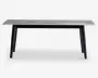 Rektangulært bord med en lysegrå bordplade med træstruktur og fire skråtstillede sorte ben. Designet er minimalistisk og moderne med rene linjer og en glat overflade. Benene er let tilspidsede, hvilket giver bordet et elegant udtryk.