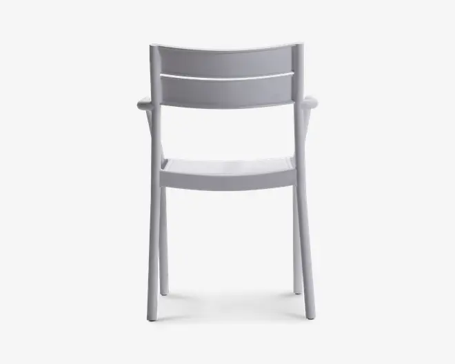 En moderne stol med minimalistisk design, udført i en ensfarvet hvid. Stolen har et let buet ryglæn med to vandrette lameller for støtte og et blødt formet sæde. Benene er lige og robuste, og armlænene er integreret i stellet, hvilket giver et strømlinet udseende. Konstruktionen ser ud til at være lavet af holdbar plast eller lignende materiale, velegnet til både indendørs og udendørs brug.