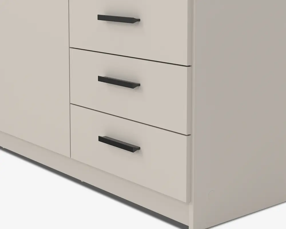 Nærbillede af en del af et møbel med tre skuffer, der har matte sorte, rektangulære greb. Overfladen er glat og har en lys beige eller offwhite farve. Skufferne er jævnt fordelt og har rene, moderne linjer, hvilket giver møblet et minimalistisk og moderne udtryk.