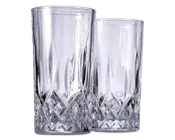 To høje, klare drikkeglas med et facetslebet diamantmønster i bunden, som giver et tekstureret og elegant udseende. Den øverste del af glassene er glat og cylindrisk, mens den nederste del har indviklet geometrisk detaljering for bedre greb og et flot visuelt udtryk.