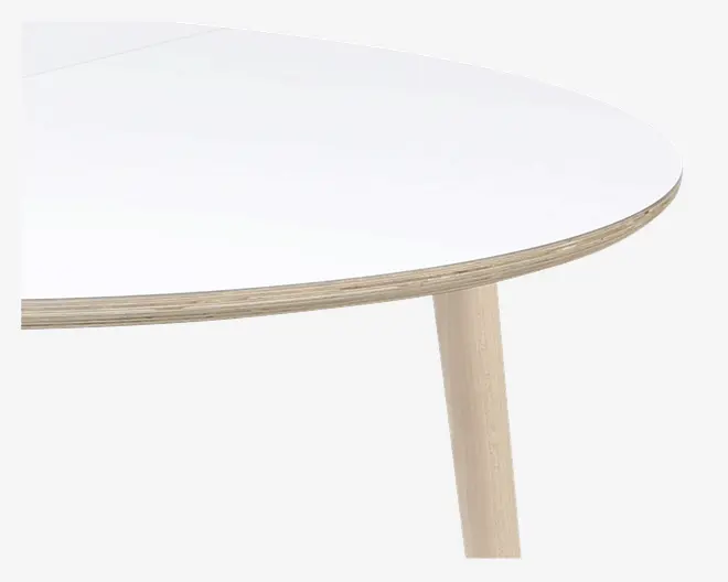 Nærbillede af et bord med en glat, hvid, afrundet bordplade og en lys træ-kant. Bordet har et cylindrisk ben i lyst træ, hvilket giver et moderne og minimalistisk udtryk.