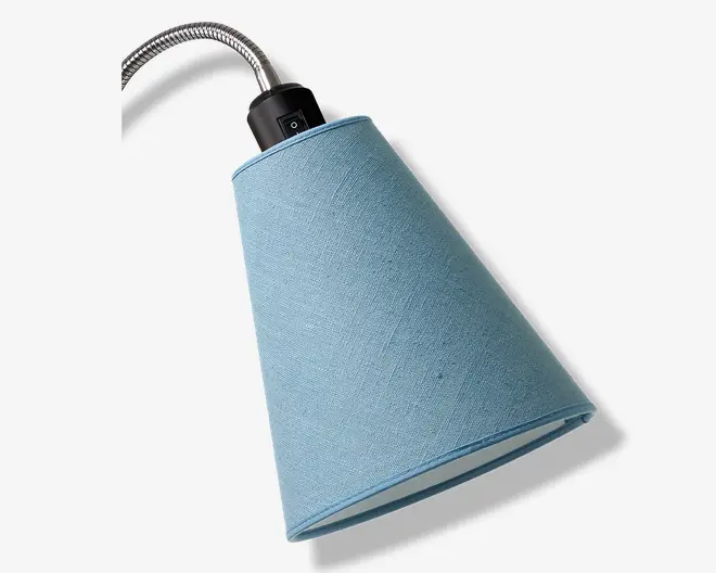 En konisk lampeskærm i blåt stof med en let tekstureret overflade. Skærmen er monteret på en fleksibel, sølvfarvet svanehals, og lampen har en sort fatning med indbygget tænd/sluk-knap. Lampeskærmens inderside er hvid, hvilket giver en god lysspredning.