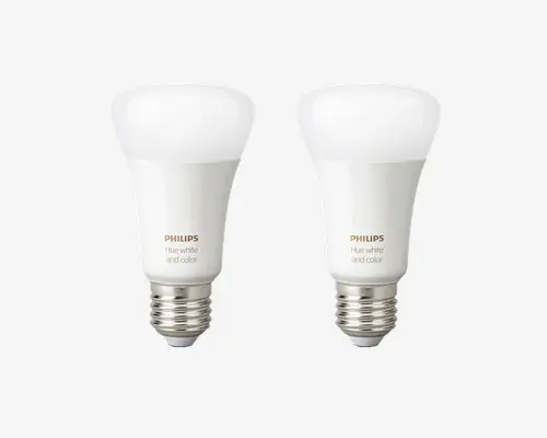 Sæt med to smarte LED-pærer med standard E27 fatning. Hver pære har en glat, hvid overflade med afrundet top og er mærket med "PHILIPS Hue white and color." Disse pærer kan levere både hvidt og farvet lys og er kompatible med smart home-systemer for tilpasset belysning.