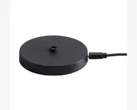 En rund, flad, sort base med mat overflade, der har et centralt gevindhul til montering. Basen er forbundet med et strømkabel på siden, hvilket indikerer, at den er elektrisk drevet eller giver elektrisk forbindelse. Designet er minimalistisk og moderne.