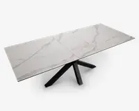 Rektangulært bord med en hvid bordplade med marmoreffekt og diskrete grå årer. Bordpladen består af tre paneler, hvilket indikerer et udtræksdesign. Bordets base har sorte, skråtstillede ben, der mødes i midten og giver et moderne og stabilt udtryk.