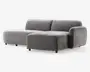 Moderne hjørnesofa med minimalistisk design, betrukket med blødt gråt stof. Sofaen har lav profil med brede, dybe sæder og én armlæn på højre side. Hynderne er tykke og bløde, hvilket giver god komfort. Benene er korte og diskrete, hvilket får sofaen til at se svævende ud. Perfekt til moderne stuer.