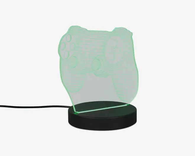 En dekorativ LED-lampe med et 3D-illusion design af en videospil-controller. Lampen består af en klar akrylplade, der er indgraveret med konturer og detaljer af controlleren, som lyser op med et blødt grønt lys, når den er tændt. Pladen er monteret på en rund, sort base, der indeholder LED-lyskilden og strømtilslutningen. Lampen får strøm via et synligt USB-kabel, hvilket gør den velegnet til skriveborde eller natborde.