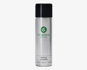 En høj, cylindrisk spraydåse med sølvfarvet krop og sort låg. Forsiden har et grønt logo og teksten 'Guardian Furniture Care' i grønt, samt 'Textile Cleaner' trykt med sort på en hvid etiket nær bunden. Dåsen har et stilrent, moderne design og ser nem ud at holde og bruge.
