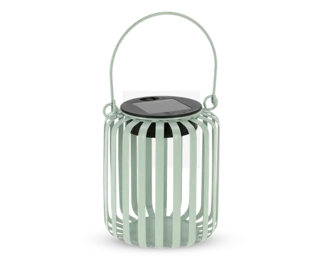 En cylindrisk lanterne med lodrette lameller lavet af lysegrønt metal. Den har en sort, rund top med indbygget solcellepanel og et matchende lysegrønt håndtag, der er fastgjort til siderne for nem transport eller ophængning. Det åbne lameldesign lader lyset skinne igennem og skaber dekorative mønstre.
