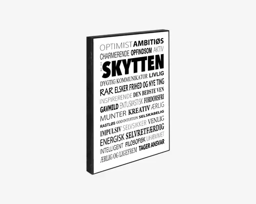 Rektangulært vægkunst med sort ramme, der viser en række positive personlighedstræk og karakteristika i fed, sort dansk tekst. Ordene er arrangeret i forskellige skrifttyper og størrelser for at fremhæve visse egenskaber, hvor det største ord er 'SKYTTEN'. Designet har en enkel, minimalistisk hvid baggrund, som får teksten til at træde tydeligt frem. Stilen er moderne og typografisk, velegnet til bolig- eller kontorindretning.
