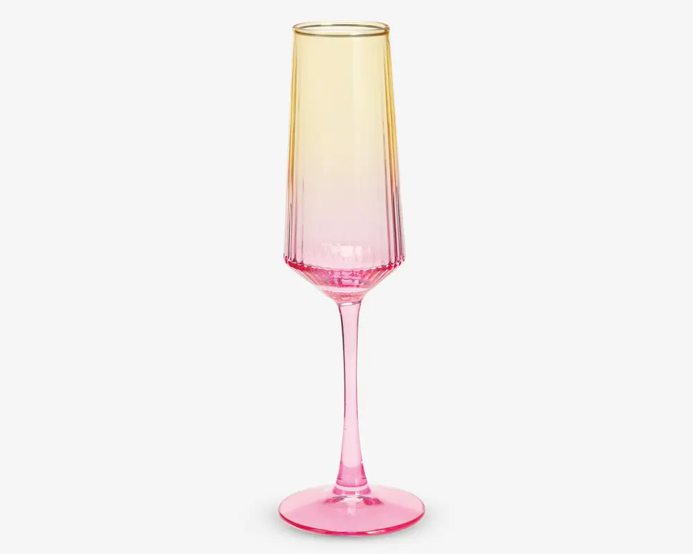 Højt, slankt glas med fløjteformet skål, der har et farveforløb fra lys gul øverst til kraftig pink ved bunden og stilken. Glasset har en glat, blank overflade og en solid rund fod for stabilitet.