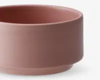 En rund skål med mat finish i en afdæmpet rosa farve. Skålen har lige sider og en let forhøjet bund, hvilket giver et moderne og minimalistisk udtryk. Overfladen er glat og uden mønstre eller hank.