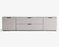 Moderne, lav opbevaringsenhed med mat lysegrå finish. Enheden har to store centrale skuffer med elegante sorte greb, flankeret af to skabslåger på hver side, også med matchende sorte greb. Designet er minimalistisk med rene linjer og en glat overflade, velegnet til moderne indretning.