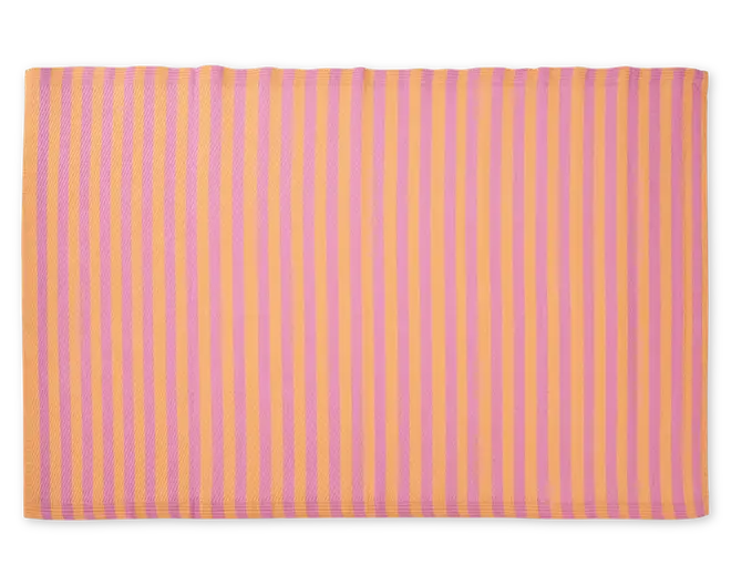 Rektangulær måtte med skiftevis lodrette striber i orange og pink. Overfladen har et diskret tekstureret mønster, og kanterne er pænt afsluttet. Farverne er klare og giver måtten et livligt og moderne udtryk.