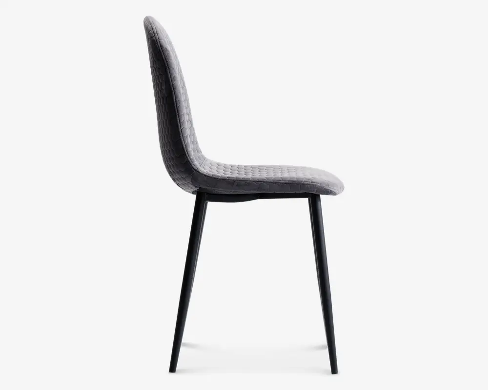 Sidevisning af en moderne stol med let buet, polstret sæde og ryglæn betrukket med gråt tekstil med struktur. Stolen har slanke, sorte metalben, der er let udadskrånende, hvilket giver et stilrent og minimalistisk udtryk. Sæde og ryglæn er sammenhængende og giver ergonomisk støtte.