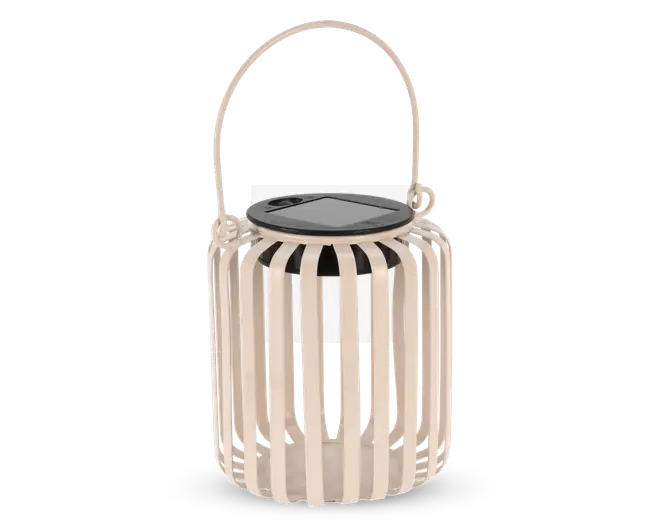 En beige lanterne med lodrette lameller, der danner en cylindrisk form, med sort top med solcellepanel og et buet håndtag i samme farve til nem transport eller ophængning. Det åbne lameldesign lader lyset skinne igennem og skaber dekorative mønstre.