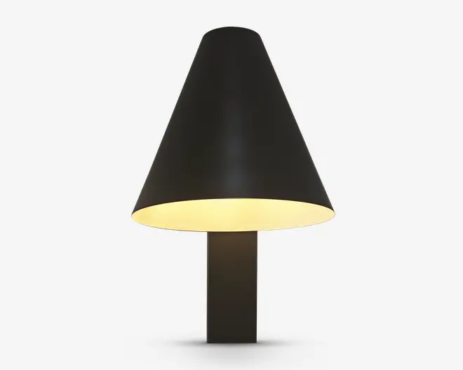 En moderne bordlampe med en mat sort, kegleformet lampeskærm og en matchende sort, rektangulær fod. Lampeskærmens inderside er hvid, hvilket reflekterer et varmt, diffust lys nedad. Designet er minimalistisk og stilrent, velegnet til moderne indretning.