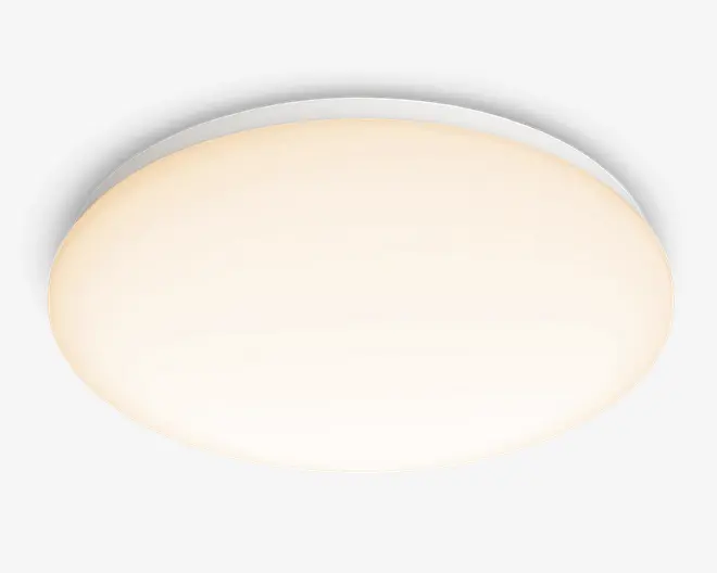 Rund loftarmatur med en glat, hvid mat skærm, der spreder lyset jævnt. Designet er minimalistisk og monteres tæt på loftet, hvilket gør det velegnet til moderne indretning. Armaturet har en slank profil og giver blød, omgivende belysning.