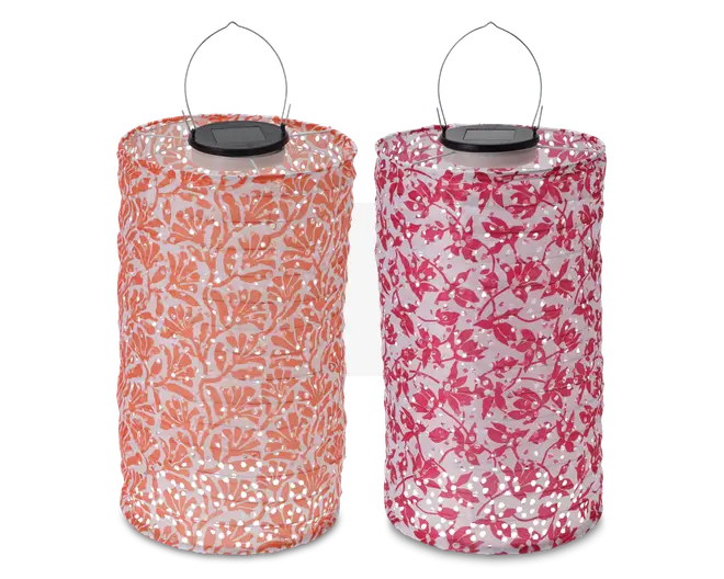 To cylindriske lanterner med metalhåndtag og solpaneler på toppen. Den venstre lanterne har et orange og hvidt bladmønster, mens den højre har et pink og hvidt blomstermønster. Begge lanterner har perforerede overflader, der lader lyset skinne igennem de dekorative mønstre.