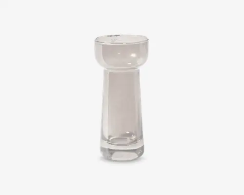 Klar glasgenstand med en cylindrisk bund, der let smalner opad og udvider sig til en rund, skålformet top. Glasset er tykt og gennemsigtigt, hvilket giver et robust udtryk. Designet er moderne og minimalistisk med glatte overflader og rene linjer.