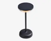 En moderne, sort bordlampe med rund fod og en slank, lodret stang. Lampen har en cirkulær top med solpaneloverflade, en gennemsigtig ring under toppen for blødt lys og en touch-tænd/sluk-knap på foden. Designet er stilrent og minimalistisk, velegnet til moderne indretning.