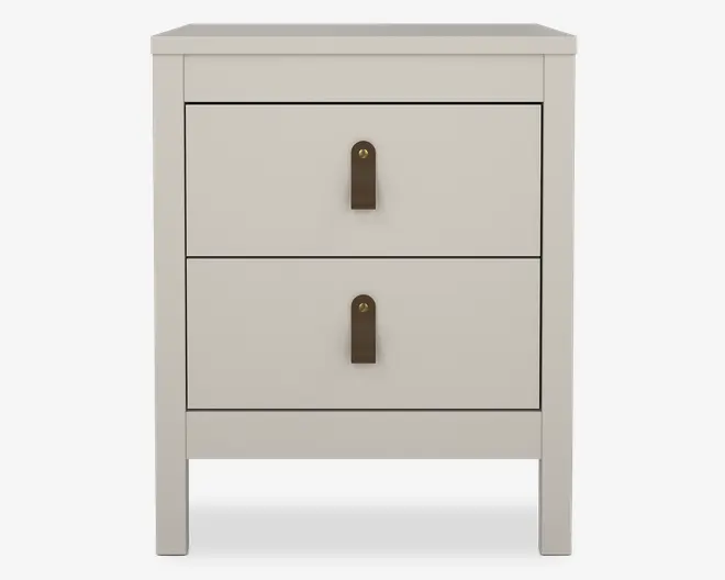 Et moderne, rektangulært natbord med en glat, mat lysebeige finish. Det har to rummelige skuffer, hver med en enkelt lodret læderstrop som greb i midten, dekoreret med en messingnitte. Designet er minimalistisk med rene linjer og let tilspidsede ben, hvilket giver et moderne udtryk.
