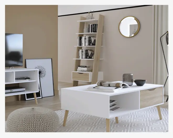 Rektangulært sofabord i moderne skandinavisk design med hvid bordplade og åbne opbevaringsrum på begge sider. Bordet står på fire skråtstillede ben i naturtræ. Opbevaringsrummene egner sig til bøger, magasiner eller dekoration. Udtrykket er minimalistisk og funktionelt og passer godt til moderne indretning.