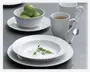 Et sæt hvidt porcelænsservice med en diskret rillet kant. Sættet består af en middagstallerken, en dyb tallerken, en skål og et krus. Skålen er fyldt med grønne limefrugter, og kruset indeholder en varm drik. Servicet har et rent, moderne design med bløde kurver og blank overflade. En grøn kvist ligger som pynt på den dybe tallerken. En ske og en gaffel i rustfrit stål er også synlige.