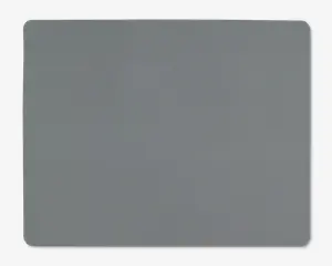 Et rektangulært underlag med afrundede hjørner og en glat, ensfarvet grå overflade. Kanterne er let hævede, og materialet ser blødt og fleksibelt ud, velegnet til brug på et skrivebord eller bord.