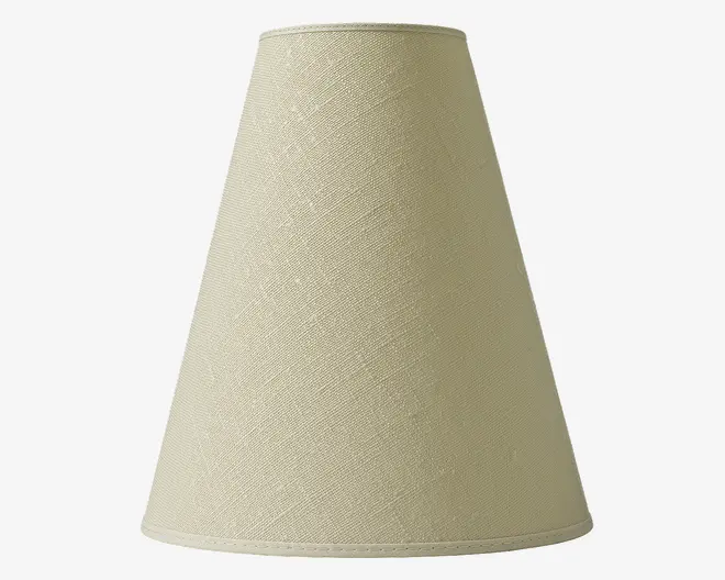 En konisk lampeskærm lavet af lysebeige stof med en diskret vævet struktur. Skærmen har et enkelt, minimalistisk design med rene linjer og en let udvidet bundkant. Stoffet er stramt spændt over stellet, hvilket giver et glat og ensartet udseende.