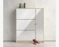 Moderne opbevaringsskab med lyst træramme og blanke hvide fronter. Skabet har tre vandrette rum til venstre og et højt, lodret rum til højre, alle med diskrete greb. Øverst står en lille potteplante, en geometrisk vase og en guldfarvet dekorationsgenstand. Et par røde højhælede sko står på gulvet foran skabet. Baggrunden er en hvid, struktureret væg og lyse gulvfliser.