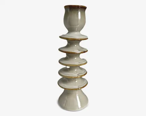 Høj, blank keramikgenstand med et stablet, etageformet design bestående af seks afrundede, skive-lignende sektioner adskilt af guldfarvede kanter. Overfladen er glat med en lys, offwhite glasur og diskrete marmoreringer. Toppen er formet som en kop, mens bunden er bredere og konisk for stabilitet.