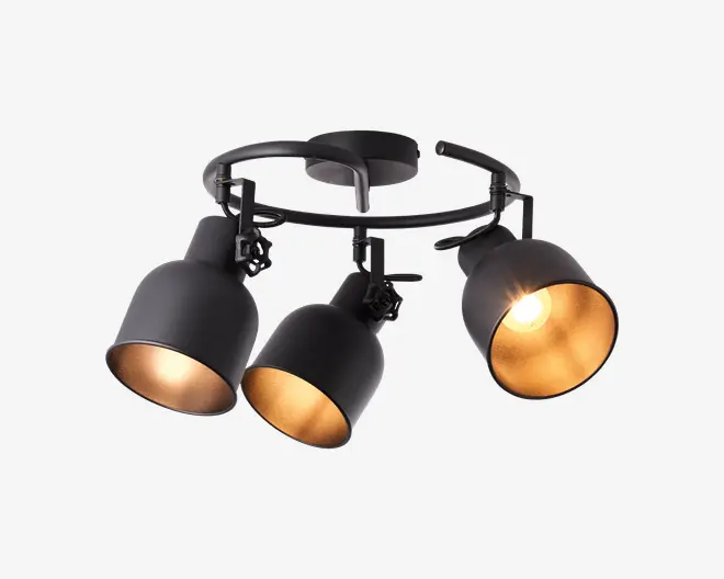 Loftmonteret lampearmatur med tre justerbare lampeskærme i mat sort metal, hver med en gylden inderside, der giver et varmt lys. Lampeskærmene er fastgjort til en sort, cirkulær ramme, hvilket muliggør retningsbestemt belysning. Én lampe er tændt og fremhæver den reflekterende gyldne inderside.