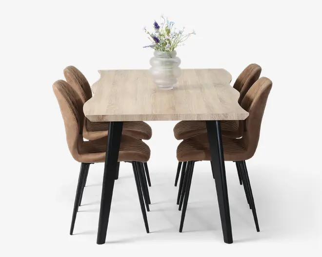 Rektangulært bord med lys træstruktur og sorte skrå ben. Bordet er kombineret med seks brunpolstrede stole, der har buede rygge og sorte metalben. En mat glasvase med en buket lilla og hvide blomster står midt på bordet.