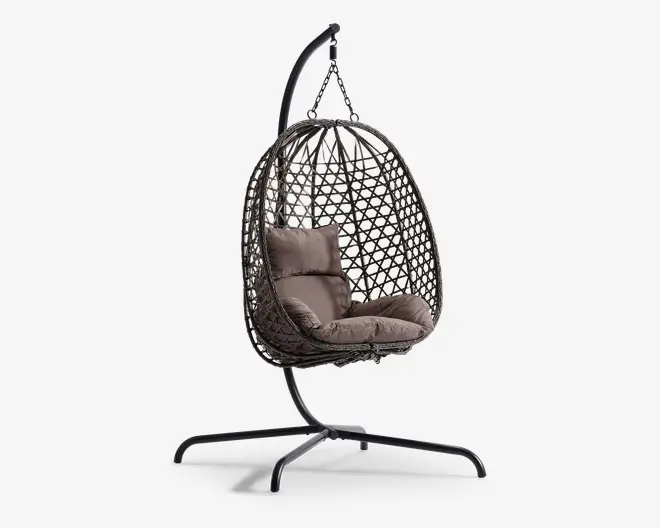 Hængende æggeformet stol med flettet rattanramme, ophængt fra et robust sort metalstativ. Stolen har bløde, taupefarvede sæde- og ryghynder for ekstra komfort. Den åbne gitterstruktur i rammen giver god luftcirkulation og et moderne udtryk. Basen er bred og stabil, hvilket sikrer sikker placering både indendørs og udendørs.