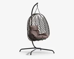 Hængende æggeformet stol med flettet rattanramme, ophængt fra et robust sort metalstativ. Stolen har bløde, taupefarvede sæde- og ryghynder for ekstra komfort. Den åbne gitterstruktur i rammen giver god luftcirkulation og et moderne udtryk. Basen er bred og stabil, hvilket sikrer sikker placering både indendørs og udendørs.