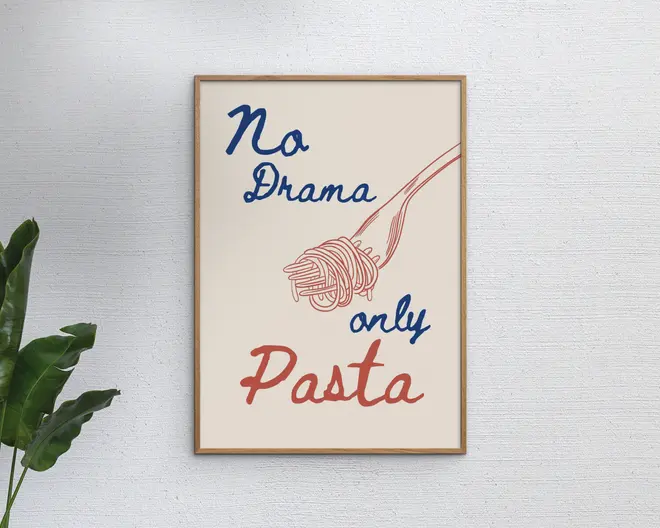 En indrammet plakat med et minimalistisk design, der viser teksten 'No Drama only Pasta' i en blanding af blå og rød håndskrevet stil. Plakaten har også en enkel stregtegning af en gaffel, der snor spaghetti, i samme røde farve som ordet 'Pasta'. Baggrunden er lys beige, og rammen er tynd og lavet af lyst træ. Udtrykket er moderne og legende.
