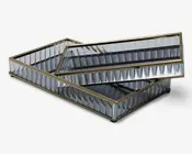 Rektangulær bakke med spejloverflader og lodrette, riflede glassider, indrammet af en slank guldfarvet metalramme. Bakken har et moderne, elegant design og vises med en mindre matchende bakke placeret indeni.