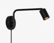 Sort vægmonteret spotlampe med rund bagplade, en L-formet justerbar arm og et cylindrisk lampehoved vinklet nedad.