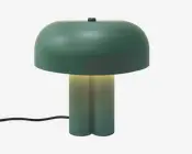 En grøn bordlampe formet som en svamp med en afrundet kuppelskærm, en cylindrisk base og varmt lys, der skinner under skærmen. En sort ledning går ud fra venstre side.