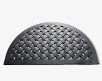 En halvcirkelformet måtte med en kraftig, hævet kant og et flettet gittermønster i midten. Måtten er lavet af holdbart sort gummi, designet til at opfange snavs og give en skridsikker overflade. De sammenlåste bånd danner et kurveflet-lignende udseende, som både er stilfuldt og funktionelt.