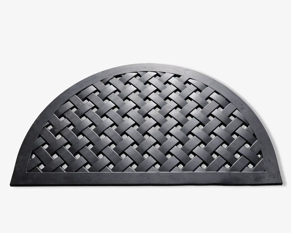 En halvcirkelformet måtte med en kraftig, hævet kant og et flettet gittermønster i midten. Måtten er lavet af holdbart sort gummi, designet til at opfange snavs og give en skridsikker overflade. De sammenlåste bånd danner et kurveflet-lignende udseende, som både er stilfuldt og funktionelt.