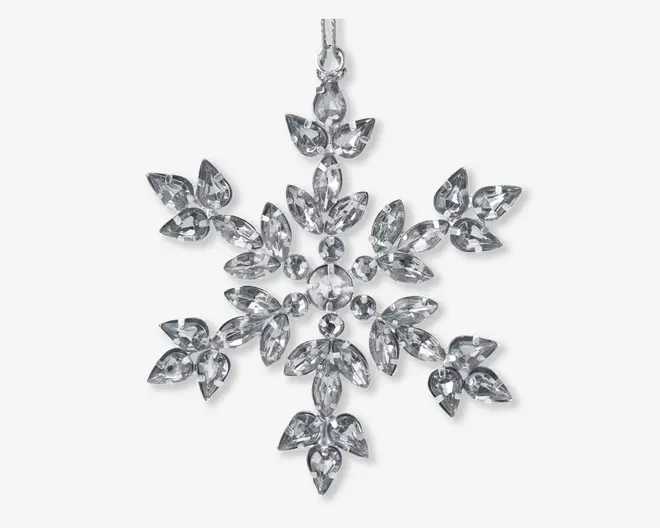 Klar, facetslebet krystalpynt formet som en snefnug med seks symmetriske arme. Hver arm er dekoreret med flere marquise-slebne og runde krystaller, hvilket giver et funklende og elegant udseende. Pynten har en lille løkke øverst til ophængning.