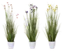 Tre arrangementer af højt, slankt kunstigt grønt græs med fine blomster i pastelrosa, lilla og gul, hver placeret i en enkel hvid cylindrisk potte. Blomsterne er små og spredt mellem græsstråene, hvilket giver et naturligt og friskt udseende. Potterne har en glat, blank overflade.