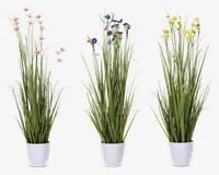 Tre arrangementer af højt, slankt kunstigt grønt græs med fine blomster i pastelrosa, lilla og gul, hver placeret i en enkel hvid cylindrisk potte. Blomsterne er små og spredt mellem græsstråene, hvilket giver et naturligt og friskt udseende. Potterne har en glat, blank overflade.