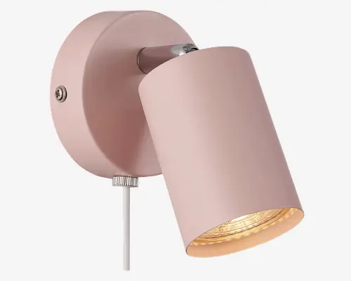 Væghængt lampe med mat pastelrosa finish. Lampens cylinderformede hoved kan justeres, så lysets retning kan ændres. Lampen har en rund base med en synlig skrue og en lille drejeknap i bunden. En hvid ledning går nedad fra basen. Lampens inderside er reflekterende for at forstærke lyset.