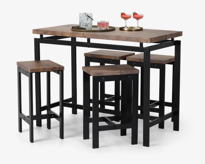Et rektangulært bord med en kraftig bordplade i naturtræ-look og sort metalstel, ledsaget af fire matchende taburetter uden ryglæn. Taburetterne har firkantede sæder i træ og solide sorte metalben med fodstøtter. Sættet har en moderne, industriel stil, og taburetterne kan skubbes ind under bordet for at spare plads. Bordet er vist med drikkevarer og en bakke ovenpå, hvilket fremhæver dets anvendelse til spisning eller underholdning.
