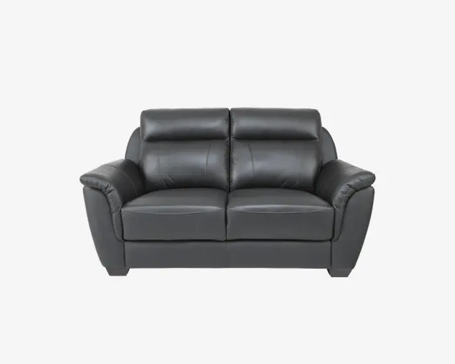 En moderne to-personers sofa betrukket med glat, mørkegråt læder. Sofaen har bløde, polstrede ryglæn og armlæn for ekstra komfort samt markerede syninger langs puderne. Sædehynderne er tykke og støttende, og det overordnede design er moderne og firkantet med let skrånende armlæn.