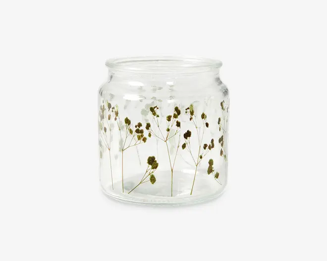 Klar glasbeholder med bred åbning og let udadbuet kant. Beholderen er dekoreret med fine, tørrede blomster og tynde stilke, som enten er indlejret i eller trykt på ydersiden, hvilket giver et naturligt og elegant udtryk. Glasset er glat og gennemsigtigt, så blomsterdetaljerne kan ses fra alle vinkler.